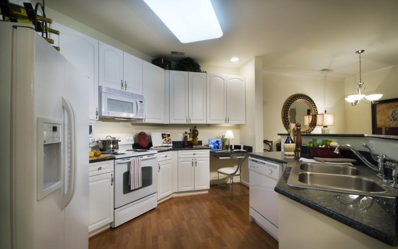 a kitchen with white cabinets and large bar