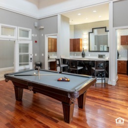 resident lounge with a pool table and kitchen area in the background